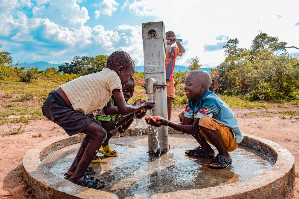 Children at an African Well hand pump